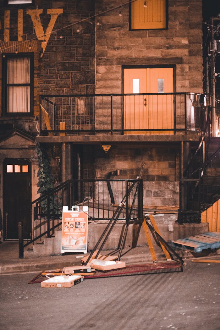 Old building facade with urban debris on a city street at night.